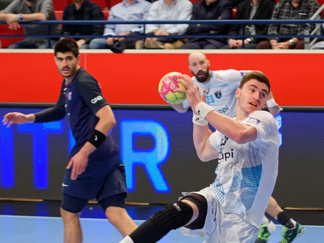 The image shows a group of men playing a game of handball on a court, with a ball in the center of...