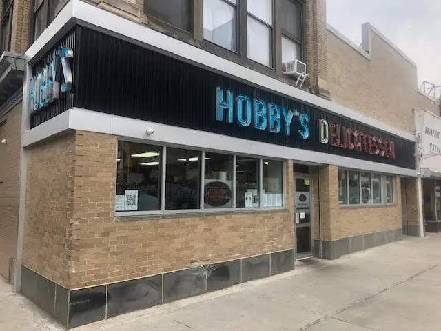 The image shows Hobby's Delicatessen in Chicago, Illinois. It is a building with glass windows and...
