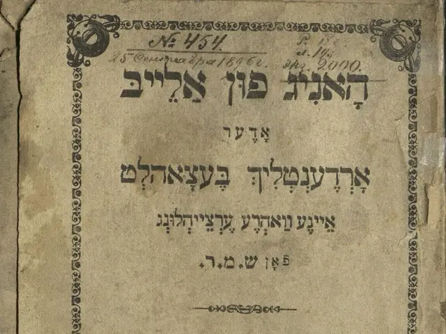 The image shows an old book with Hebrew writing on it placed on a surface. The text on the book is...