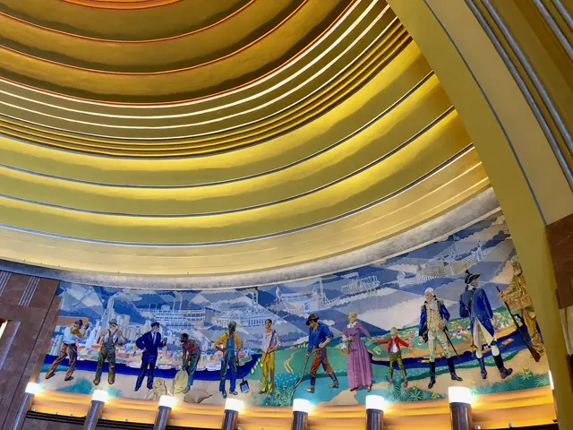 The image shows a large mural on the ceiling of a building, depicting people, buildings, and other...