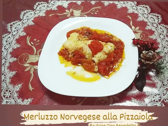 The image shows a plate of merluzzo norvegese alla pizzaiola, a traditional Italian dish, on a...