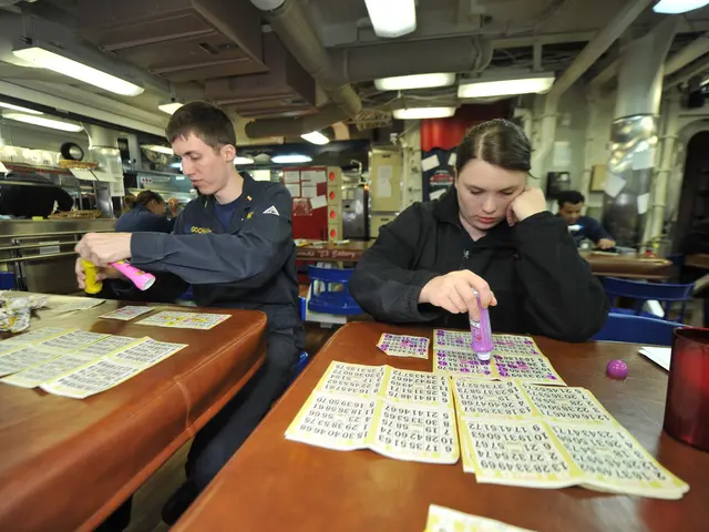 The image shows a man and woman sitting at a table playing a game of bingo. On the table there are...